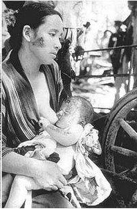 Imagen de señora dando el pecho a bebé durante un conflicto bélico